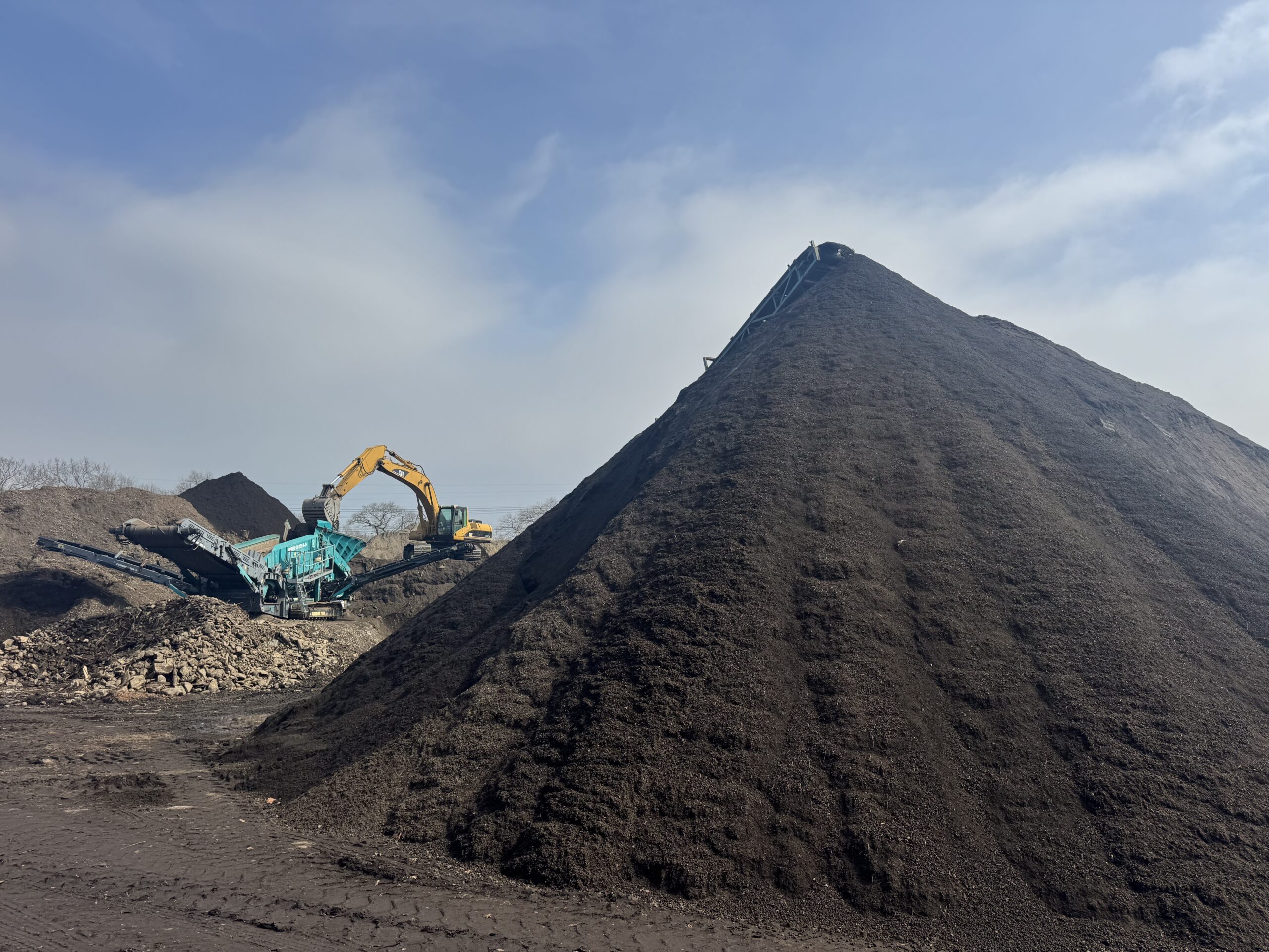 Bulk screened topsoil stockpile with screening operation at Grillo Services facility in Milford CT