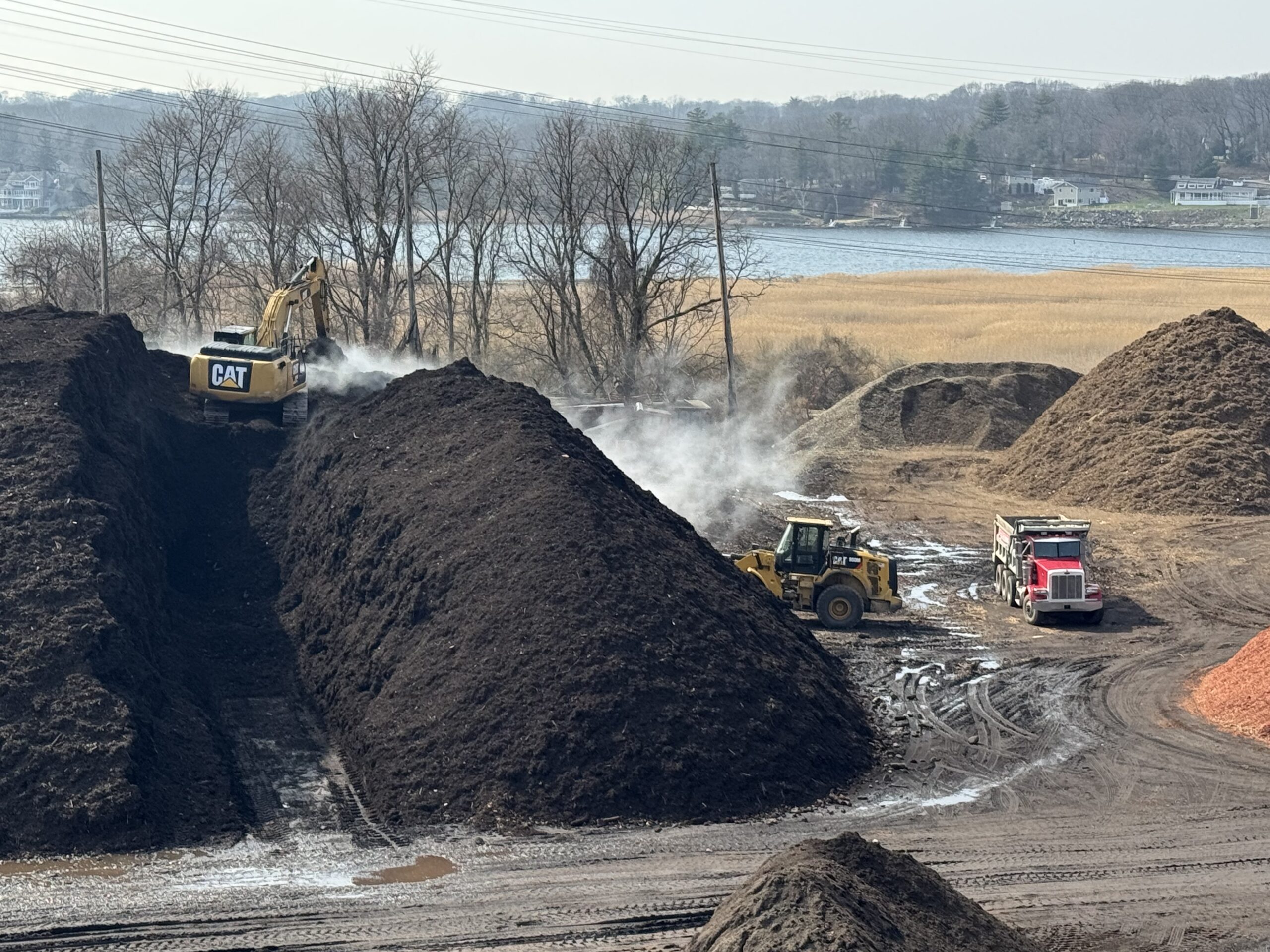 Bulk organic leaf compost stockpile at Grillo Services facility in Milford CT — a key ingredient in screened topsoil